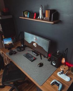 a desk with a monitor, keyboard and mouse on it in front of a black wall