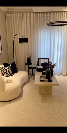 a living room filled with furniture and white curtains