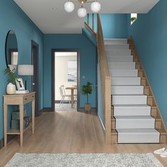 a room with blue walls and white carpeted stairs leading up to the second floor