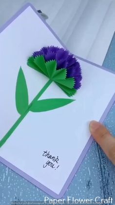 a hand holding up a card with a flower on it that says thank you, paper flowers craft