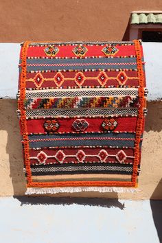 a colorful rug hanging on the side of a building