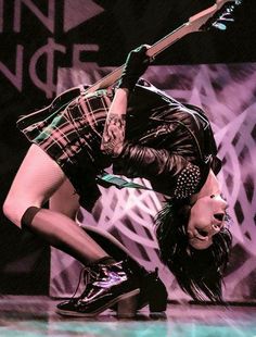 a woman is performing on stage with a guitar