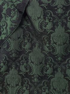 a close up view of a green and black wallpaper with an intricate design on it