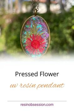 a flower is shown in the center of a glass pendant with text that reads, pressed flower an resin pendentt