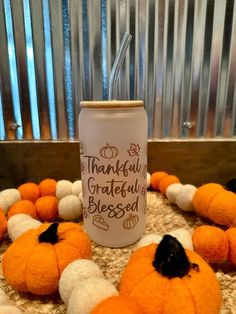 an orange and white pumpkin shaped drink in front of a group of smaller pumpkins