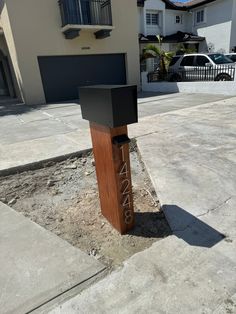 a mailbox sitting on the side of a road in front of a building with garages