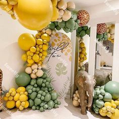 an elephant, giraffes and balloons are on display in a room with white walls