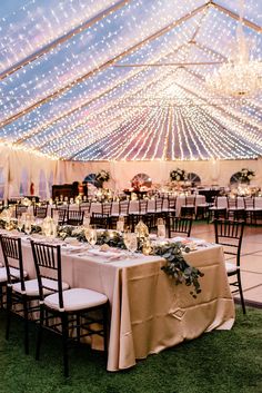 the inside of a tent with tables and chairs set up for an outdoor wedding reception