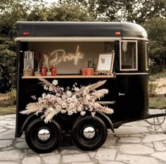 an old fashioned food truck is decorated with flowers