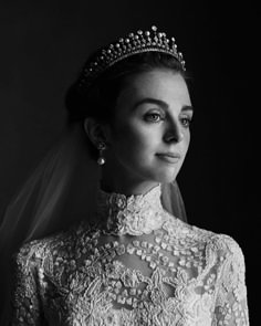 a woman in a wedding dress with a tiara on her head and veil over her shoulder