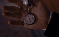 a person holding an old pocket watch in their hand