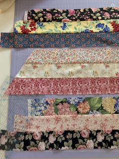 several different types of fabric laid out on top of each other, with flowers and leaves