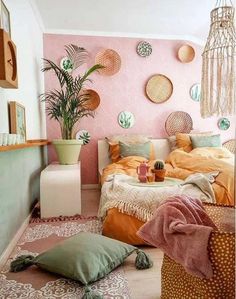 a bedroom with pink walls and lots of pillows on the floor next to a bed