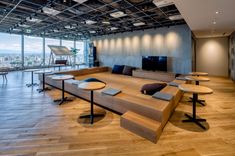 an empty room with tables and benches in front of a large window that overlooks the city