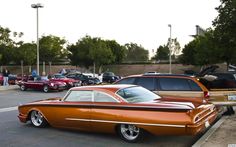 an orange classic car parked in a parking lot