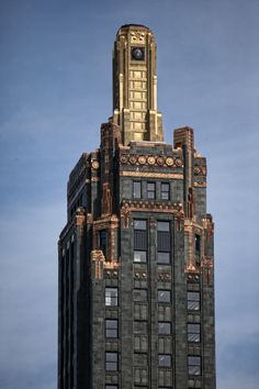 the top of a tall building with a clock on it's face and windows