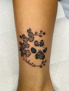 a dog paw and flower tattoo on the ankle