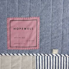 a close up of a blue and white quilt with a pink label on the back