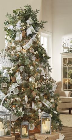 a decorated christmas tree in a living room with presents on the top and candles around it