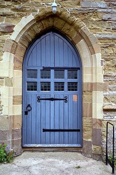 a blue door is in an old stone building