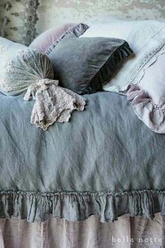 a bed with two pillows on top of it and some ruffles around the edges