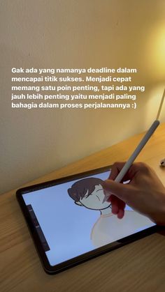 a person is drawing on an ipad with a pen and paper in front of them