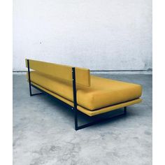 a yellow couch sitting on top of a cement floor