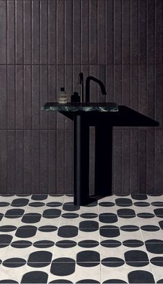 a bathroom with black and white tiles on the floor, sink and mirror in it