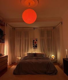 a bedroom with a large bed and two lights on the ceiling