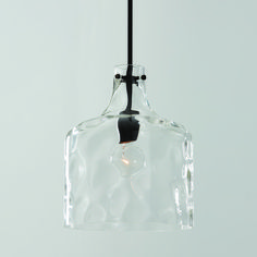 a clear glass light hanging from a black metal hook on a gray wall with a white background