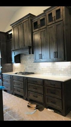 a kitchen with dark cabinets and white counter tops