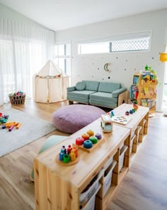 a child's playroom with toys on the floor and furniture in the background