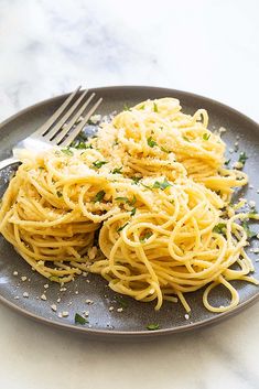 a plate full of spaghetti with parmesan cheese and chives on the side