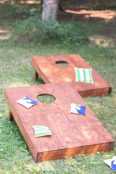 two wooden boards sitting in the grass with flags painted on them and one board has been made to look like a cornhole