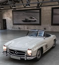 an old mercedes sports car parked in a garage