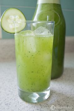 a cucumber in a glass next to a bottle