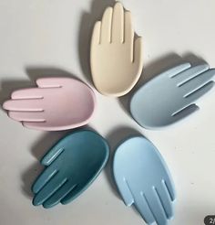 five plastic utensils arranged in a circle on a white surface with one holding the other's hand