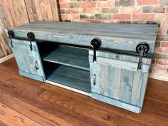 an entertainment center made out of wood with metal handles and sliding doors on one side