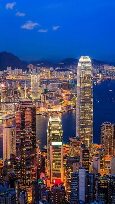 an aerial view of hong kong at night with the city lights lit up in bright colors