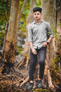 a young man standing in the middle of a forest with his hands on his hips