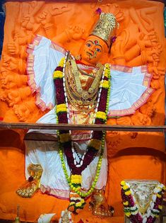 an idol is displayed in the middle of a room with orange walls and decorations around it