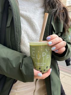 a woman holding a cup with a straw in it