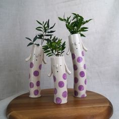 three vases with plants in them sitting on a table