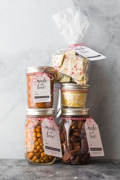 three jars filled with nuts and crackers on top of a counter next to each other