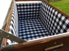 an old suitcase with a checkered fabric seat cover in it's bottom compartment