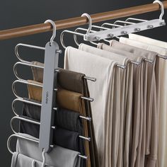 a rack with clothes hanging on it and some folded up sheets in front of them