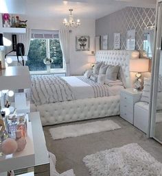 a bedroom with a large bed and white furniture