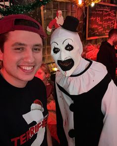 a man standing next to a creepy clown