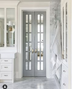 a bathroom with marble floors and double doors