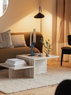 a living room with a couch, coffee table and mirror